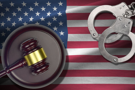 United States of America flag with judge mallet and handcuffs in dark room. Concept of criminal and punishment, background for guilty topicsの写真素材
