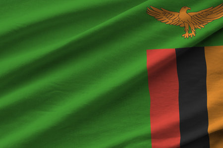 Zambia flag with big folds waving close up under the studio light indoors. The official symbols and colors in fabric bannerの写真素材
