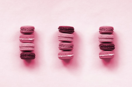 Dessert cake macaron or macaroon on trendy background top view. Flat lay composition. Image toned in...