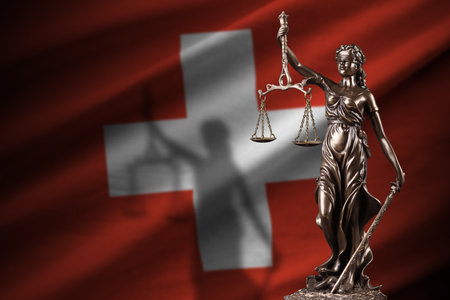 Switzerland flag with statue of lady justice and judicial scales in dark room. Concept of judgement and punishment, background for jury topicsの写真素材