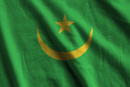 Mauritania flag with big folds waving close up under the studio light indoors. The official symbols and colors in fabric bannerの写真素材