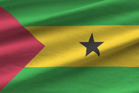 Sao Tome and Principe flag with big folds waving close up under the studio light indoors. The...
