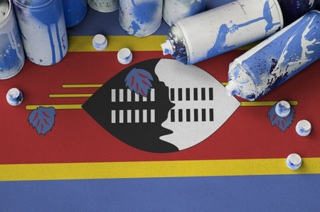 Swaziland flag and few used aerosol spray cans for graffiti painting. Street art culture concept, vandalism problemsの写真素材