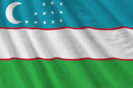 Uzbekistan flag with big folds waving close up under the studio light indoors. The official symbols and colors in fabric bannerの写真素材