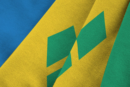 Saint Vincent and the Grenadines flag with big folds waving close up under the studio light indoors. The official symbols and colors in fabric bannerの写真素材