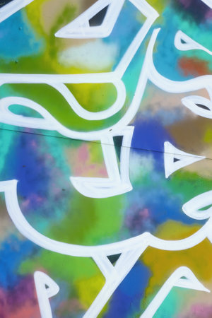 Colorful background of graffiti painting artwork with bright aerosol strips on metal wall. Old...