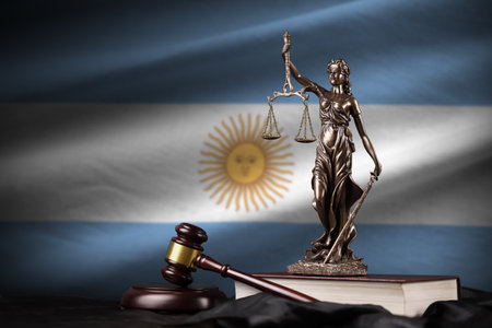 Argentina flag with statue of lady justice, constitution and judge hammer on black drapery. Concept of judgement and punishmentの写真素材