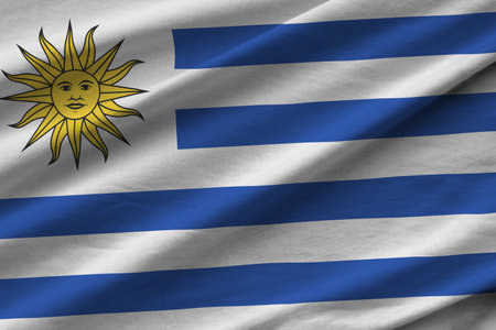 Uruguay flag with big folds waving close up under the studio light indoors. The official symbols and colors in fabric bannerの写真素材