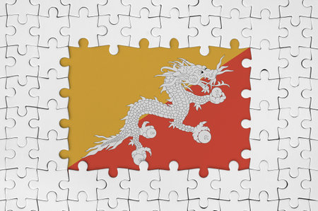 Bhutan flag in frame of white puzzle pieces with missing central partsの写真素材