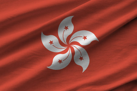 Hong kong flag with big folds waving close up under the studio light indoors. The official symbols and colors in fabric bannerの写真素材
