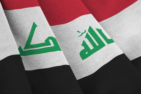 Iraq flag with big folds waving close up under the studio light indoors. The official symbols and colors in fabric bannerの写真素材