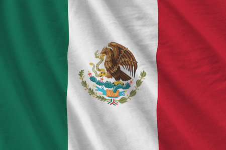 Mexico flag with big folds waving close up under the studio light indoors. The official symbols and colors in fabric bannerの写真素材