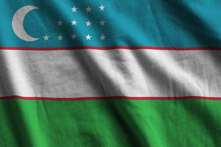 Uzbekistan flag with big folds waving close up under the studio light indoors. The official symbols and colors in fabric bannerの写真素材
