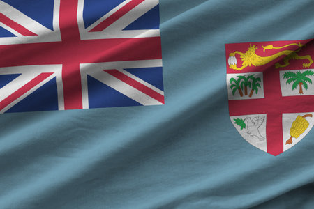 Fiji flag with big folds waving close up under the studio light indoors. The official symbols and colors in fabric bannerの写真素材