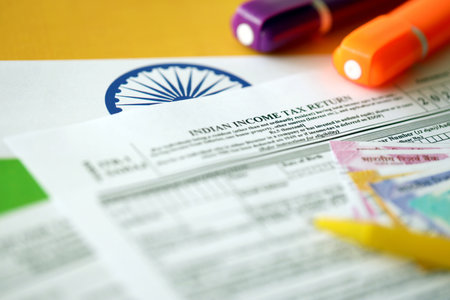KYIV, UKRAINE - MAY 4, 2022 Indian income tax return blank form with pen and indian rupees bills on indian country flag close up. Annual tax report conceptのeditorial素材