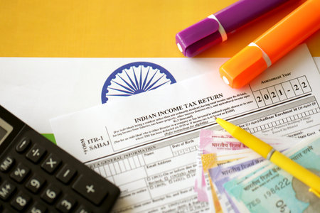 KYIV, UKRAINE - MAY 4, 2022 Indian income tax return blank form with pen and indian rupees bills on indian country flag close up. Annual tax report conceptのeditorial素材