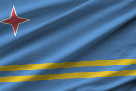 Aruba flag with big folds waving close up under the studio light indoors. The official symbols and colors in fabric bannerの写真素材