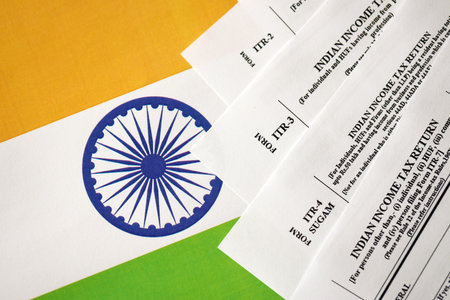 KYIV, UKRAINE - MAY 4, 2022 Indian income tax return blank forms on indian country flag close up. Annual tax report conceptのeditorial素材