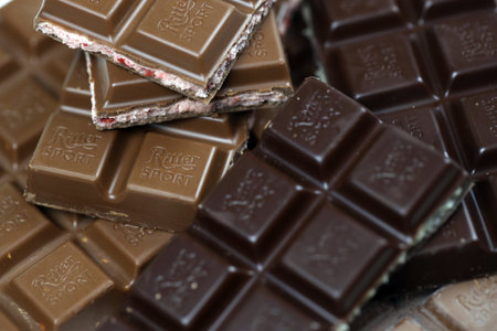 KYIV, UKRAINE - MAY 4, 2022 Ritter Sport chocolate bars with various tastes without wrappings. Many chocolate tiles with different flavours close up with Ritter Sport logoのeditorial素材