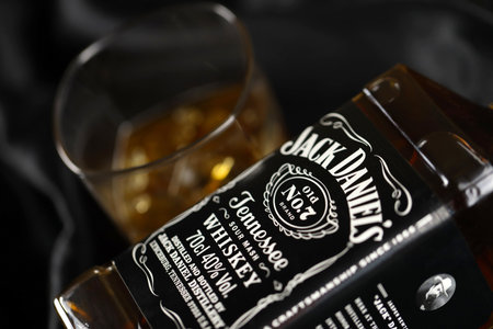 KYIV, UKRAINE - MAY 4, 2022 Jack Daniels original alcohol bottle on wooden table with black fabric on background. Elite alcohol productionのeditorial素材