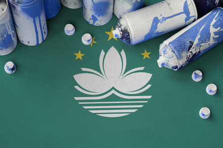 Macau flag and few used aerosol spray cans for graffiti painting. Street art culture concept, vandalism problemsの写真素材