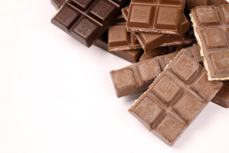 KYIV, UKRAINE - MAY 4, 2022 Ritter Sport chocolate bars with various tastes without wrappings. Many chocolate tiles with different flavours close up with Ritter Sport logoのeditorial素材