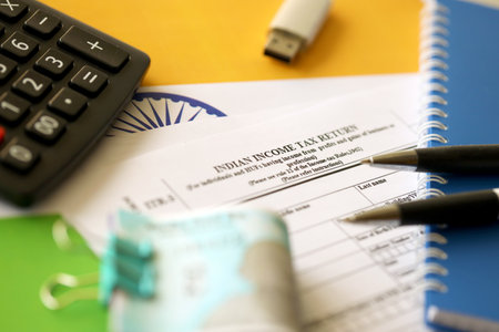 KYIV, UKRAINE - MAY 4, 2022 Indian income tax return blank form with pen and indian rupees bills on indian country flag close up. Annual tax report conceptのeditorial素材