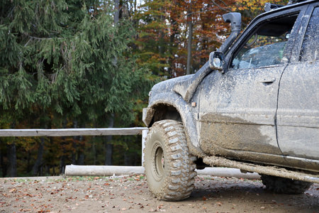 Wheel closeup in a countryside landscape with a mud road. Off-road 4x4 suv automobile with ditry...