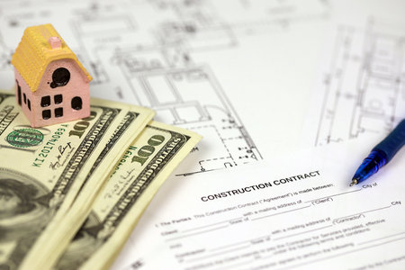 Residential construction agreement ready to sign with small toy houses and pen. Construction...