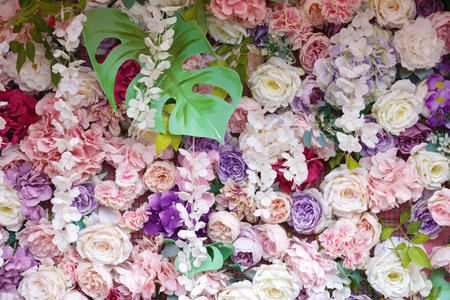 Floral background. Lot of artificial flowers in colorful composition on handmade wooden pink...