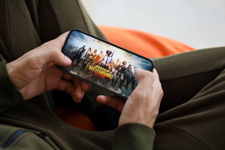 PUBG PlayerUnknowns Battlegrounds mobile iOS game on iPhone 15 smartphone screen in male hands during mobile gameplay. Mobile gaming and entertainment on portable deviceのeditorial素材