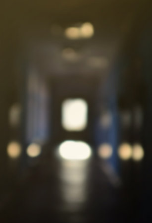 The blurred image of gloomy corridor of a neglected public building. Defocused picture of a public space in a poor residential high-rise buildingの写真素材