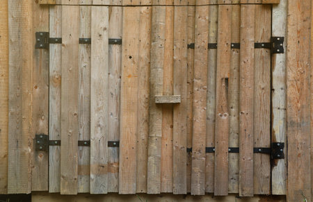 Old wooden door from farm barn made with handmade wood planks close up