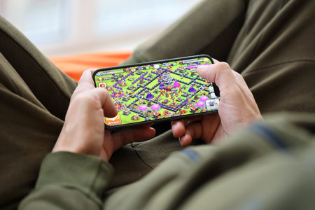 Clash of Clans mobile iOS game on iPhone 15 smartphone screen in male hands during mobile gameplay....