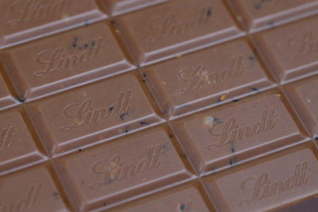 KYIV, UKRAINE - MAY 4, 2022 Lindt Swiss luxury brand chocolate brown tablets with embossed original company logo.のeditorial素材