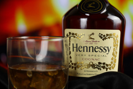 KYIV, UKRAINE - MAY 4, 2022 Hennessy Very Special original alcohol bottle on wooden table with red fireplace on background. Elite alcohol productionのeditorial素材