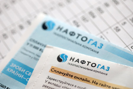 KYIV, UKRAINE - JULY 7, 2023 Naftogaz utility bill document with ukrainian hryvnias money on tableのeditorial素材