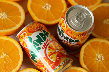 KYIV, UKRAINE - JULY 7, 2023 Mirinda orange drink with many fresh oranges on colorful backgroundのeditorial素材