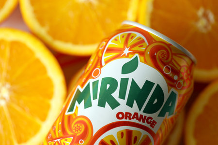 KYIV, UKRAINE - JULY 7, 2023 Mirinda orange drink with many fresh oranges on colorful backgroundのeditorial素材