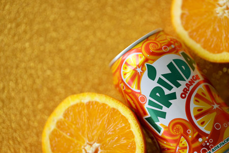 KYIV, UKRAINE - JULY 7, 2023 Mirinda orange drink with many fresh oranges on colorful backgroundのeditorial素材