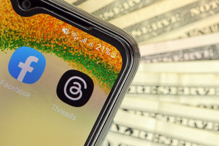 KYIV, UKRAINE - JULY 7, 2023 Threads by Meta application on display of Samsung smartphone and many dollar bills on tableのeditorial素材