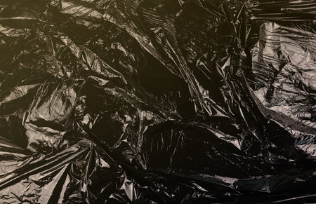 Texture of black plastic garbage disposable bag close up