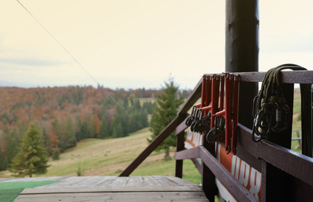 large metal locking carabiners with rope, climbing gear hanging on the store room. Height safety harness and arborist equipment close upの写真素材