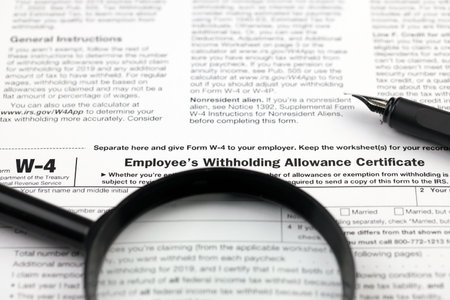 IRS Form W-4 Employees withholding allowance certificate blank on A4 tablet lies on office table...