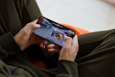 Roblox mobile iOS game on iPhone 15 smartphone screen in male hands during mobile gameplay. Mobile gaming and entertainment on portable deviceのeditorial素材