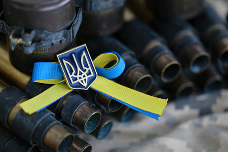 Ukrainian symbol on machine gun belt lies on ukrainian pixeled military camouflage close upの写真素材