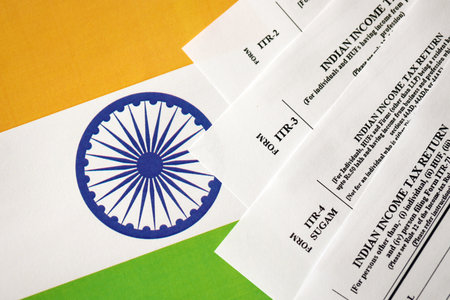 Indian income tax return blank forms on indian country flag close up. Annual tax report concept