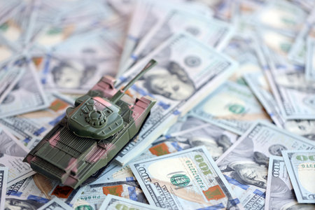 Toy tank on US hundred dollar bills banknotes close up. The concept of war costs, military spending and economic crisisの写真素材