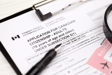 Application for Canadian citizenship for adults on A4 tablet lies on office table with pen and magnifying glass close upの写真素材