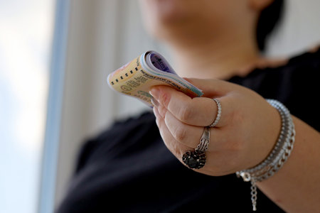 Woman hand with indian rupees bills close up. Concept of financial operations in cash in Indiaの写真素材